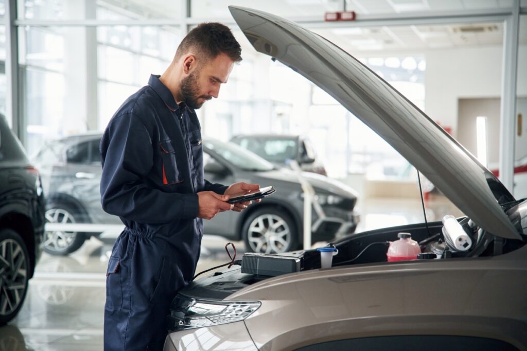 view from the side. car repairman is in the garage with automobile